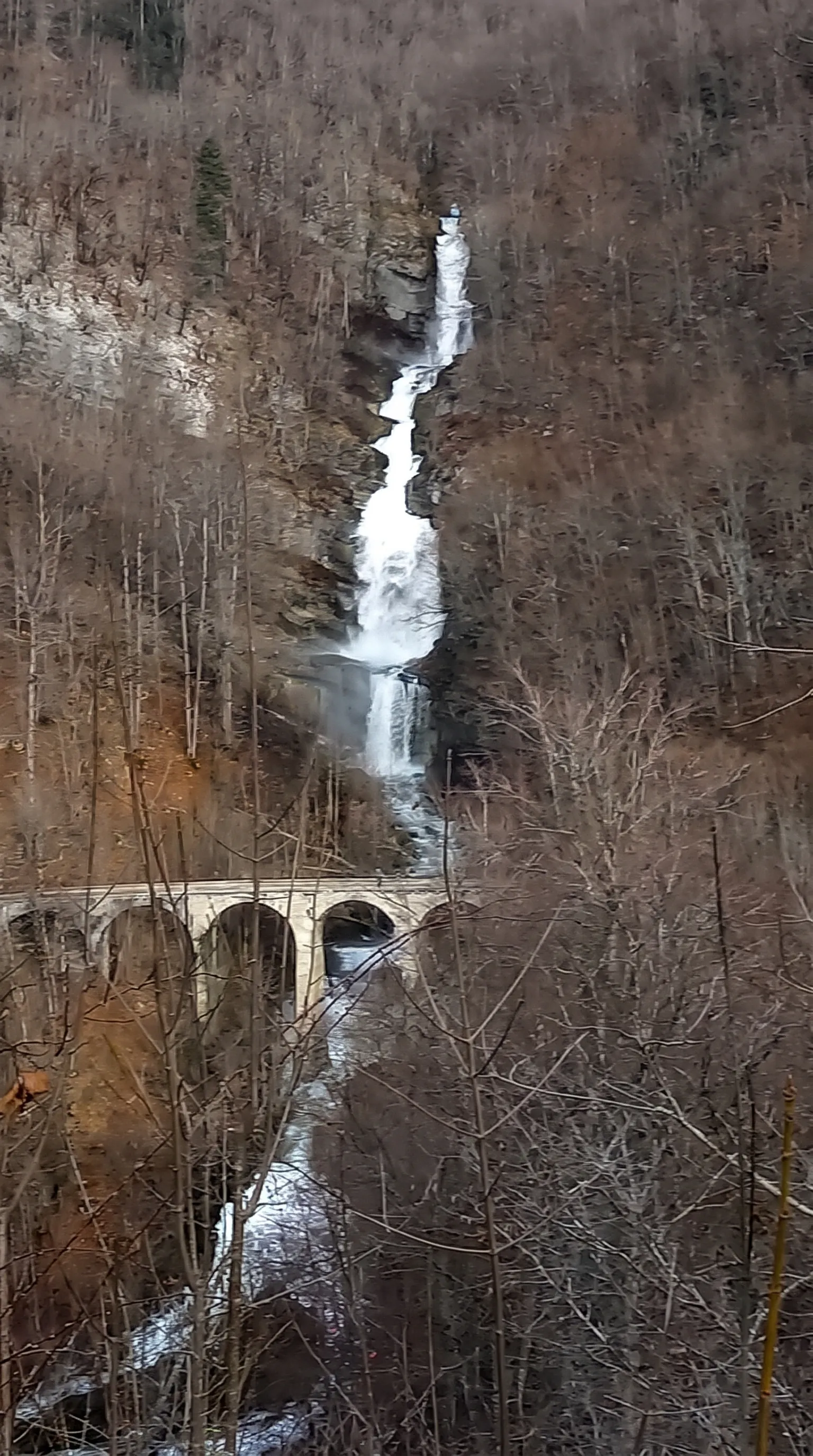 Une haute cascade et un viaduc ferroviaire en hiver